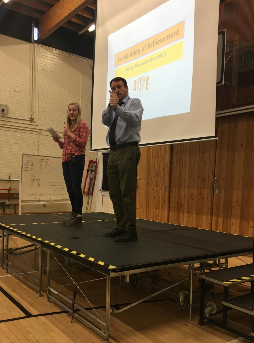 Deafie Blogger on a stage giving speech with an Interpreter to her right