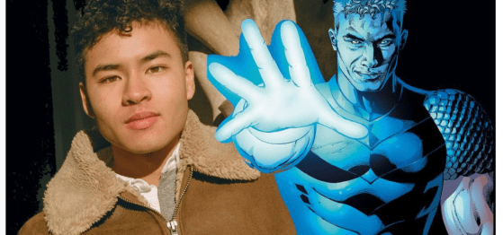 Photo of Chella Man on left wearing a brown fur lined coat and to the right is a blue superhero character with his hand out in front