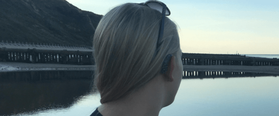 Looking out onto the beach, close up of the back of my hearing aids. I have sunglasses on my head